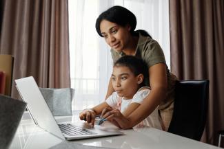 Mother and child working on a laptop together